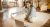 Indoor image of flexible active mature gray haired female sitting on floor in front of open laptop, stretching legs during online yoga lesson, watching live video with professional instructor